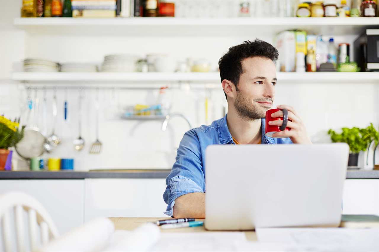 Man working from home on a laptop with a coffee